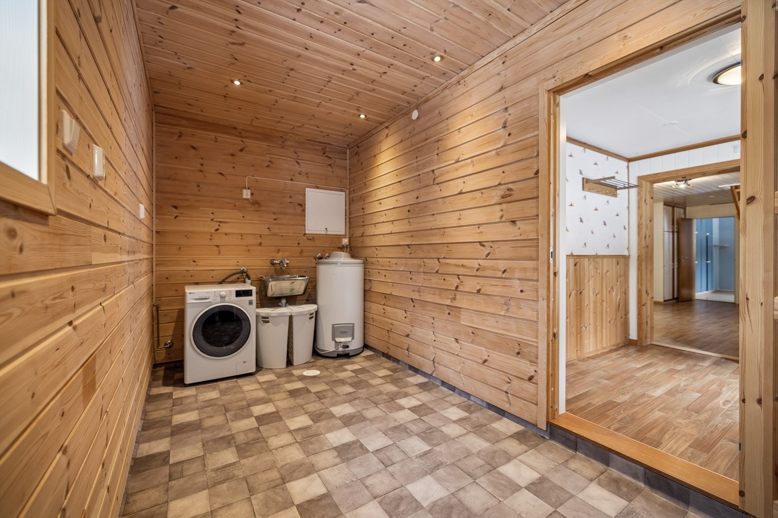 Praktisk vaskerom med vinylbelegg, varmekabler og opplegg for vaskemaskin. Galleribilde