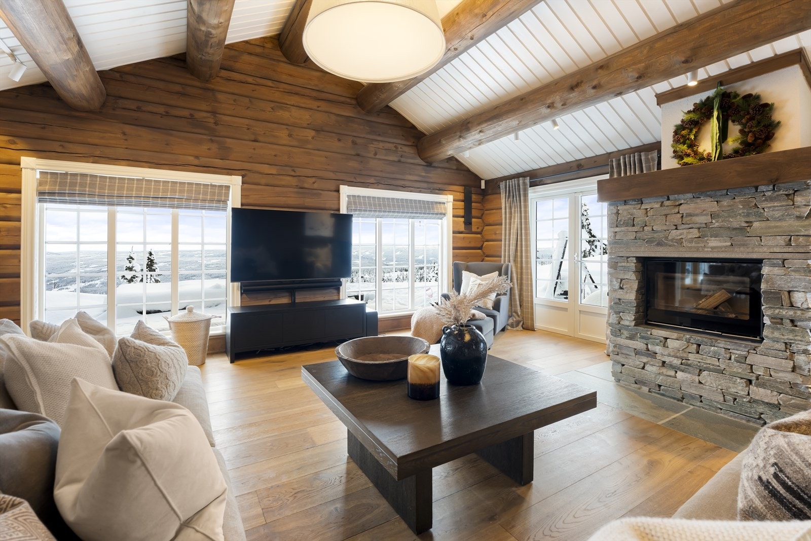 Hytta byr på et romslig og sosialt oppholdsrom som kombinerer stue og kjøkken i en åpen, men tydelig soneinndelt løsning. Galleribilde