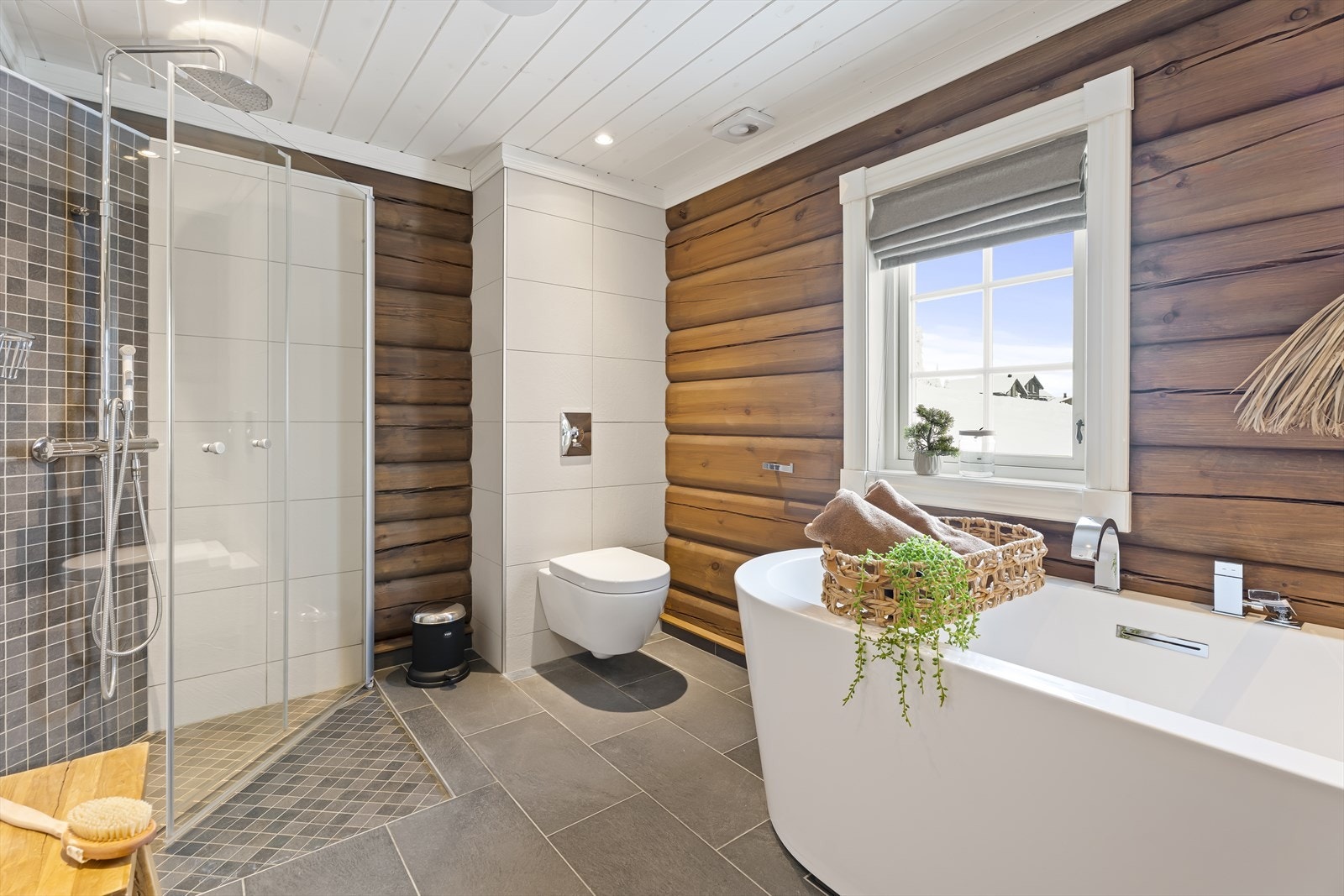 Bad nr. 2 i første etasje er innredet med servant med underskap, speil med belysning, dusjvegger, badekar og vegghengt toalett. Galleribilde