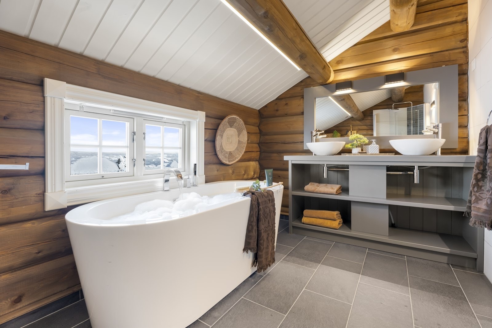 Badet i andre etasje er utstyrt med servant med underskap, speil med tilhørende belysning, dusjvegger, badekar og vegghengt toalett. Galleribilde