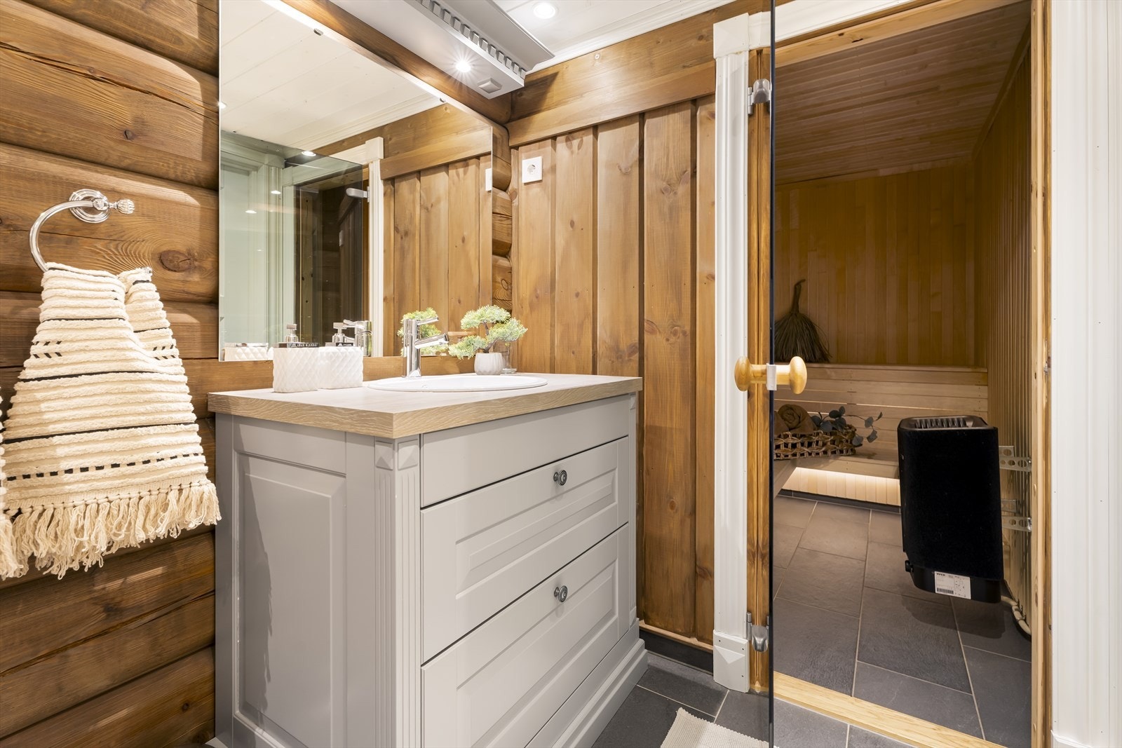 Bad nr. 1 i første etasje består av servant med underskap, speil, dusjvegger, vegghengt toalett, samt tilgang til badstuen. Innredning fra Sigdal. Galleribilde