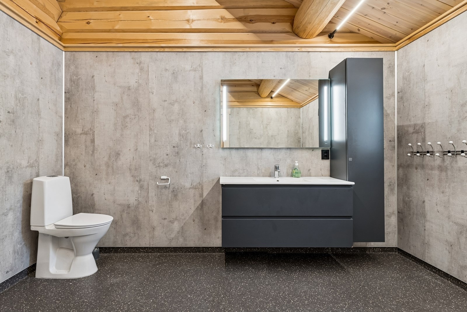 Innredningen på hovedbadet består av en stor skuffeseksjon med helservant, speil med lys og høyskap. Galleribilde