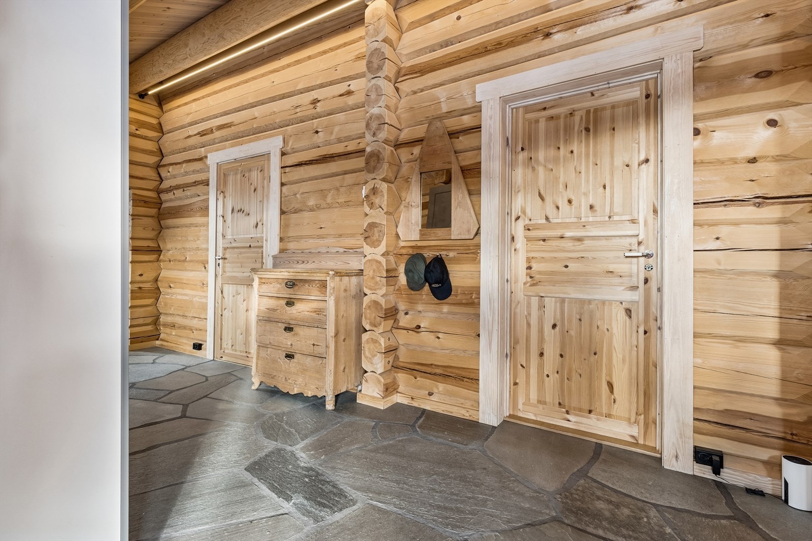 Heltre furudører og synlig laft understreker det solide håndverket i hele boligen. Galleribilde