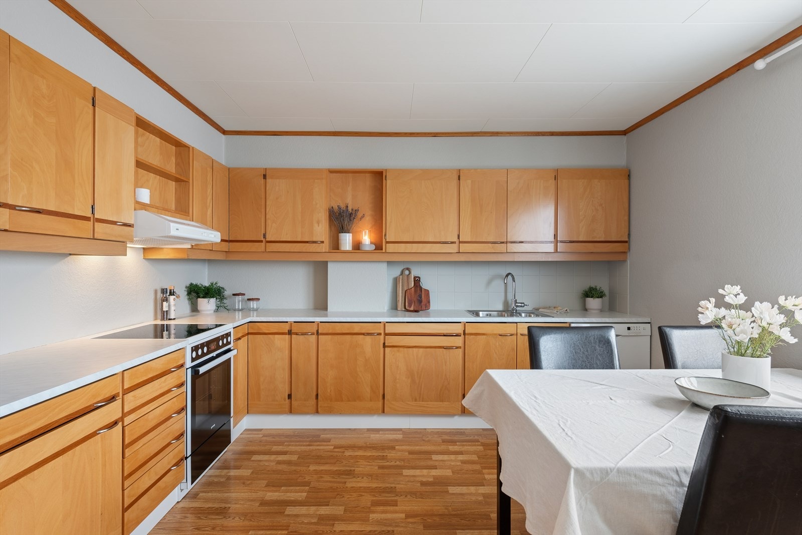 Kjøkkenet har innredning med glatte fronter som tilbyr rikelig med oppbevaringsplass i over- og underskap. Galleribilde