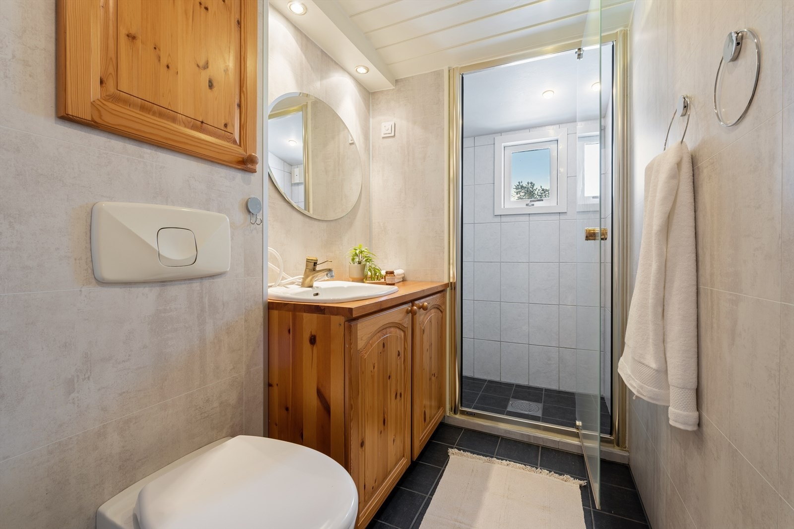 Boligens andre bad er flislagt og med elektriske varmekabler i gulv. Veggene er flislagt i dusjen og himling er malte plater. Galleribilde