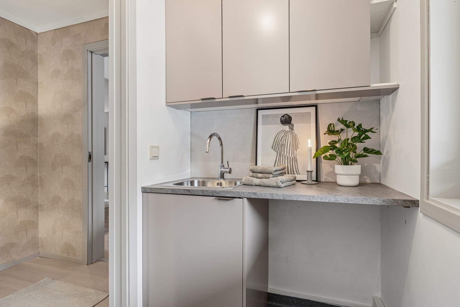 Rommet er innredet med servant med benk og har opplegg til vaskemaskin. Galleribilde