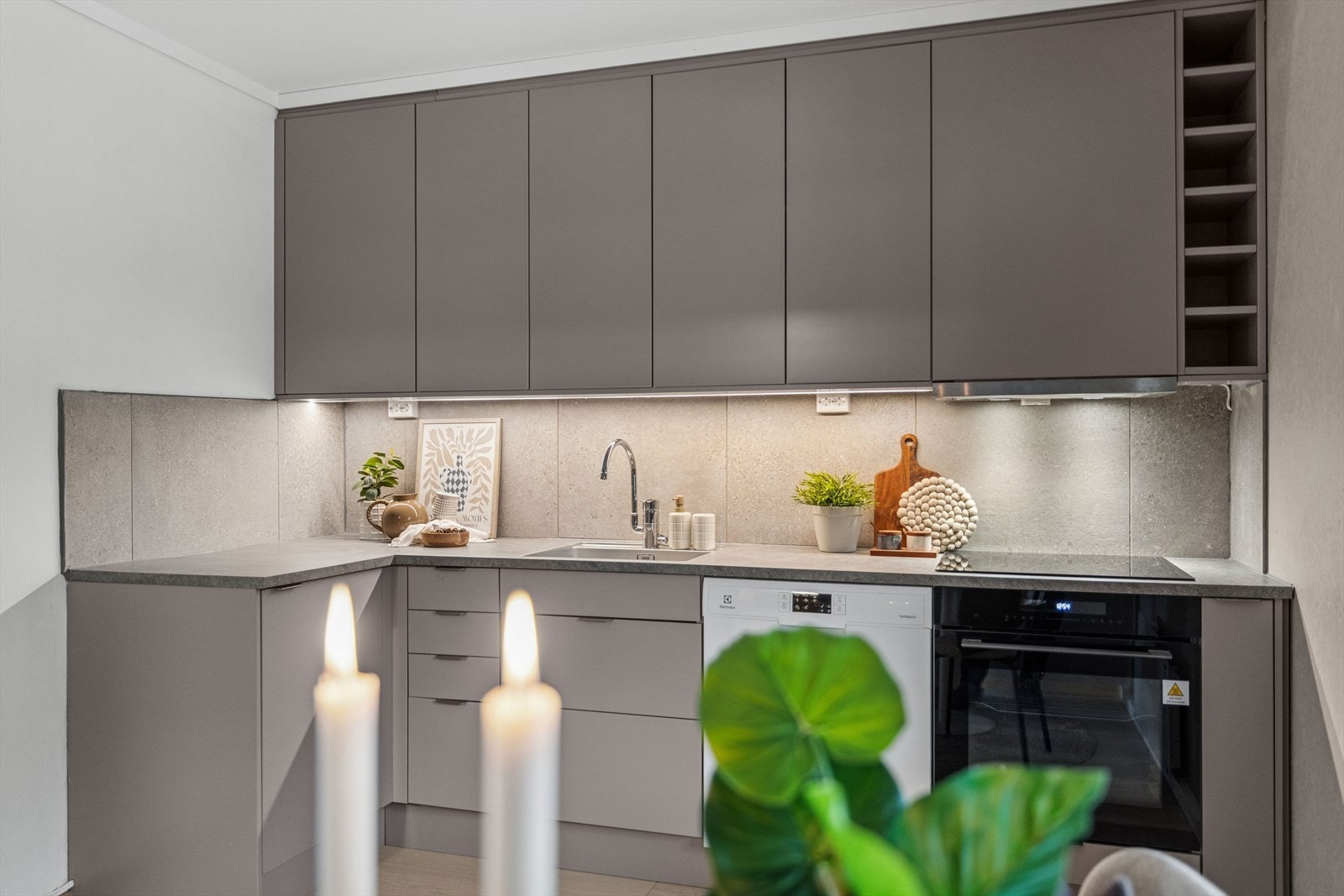 Flis på vegg under overskap. Det er montert komfyrvakt og lekkasjestopper. Galleribilde