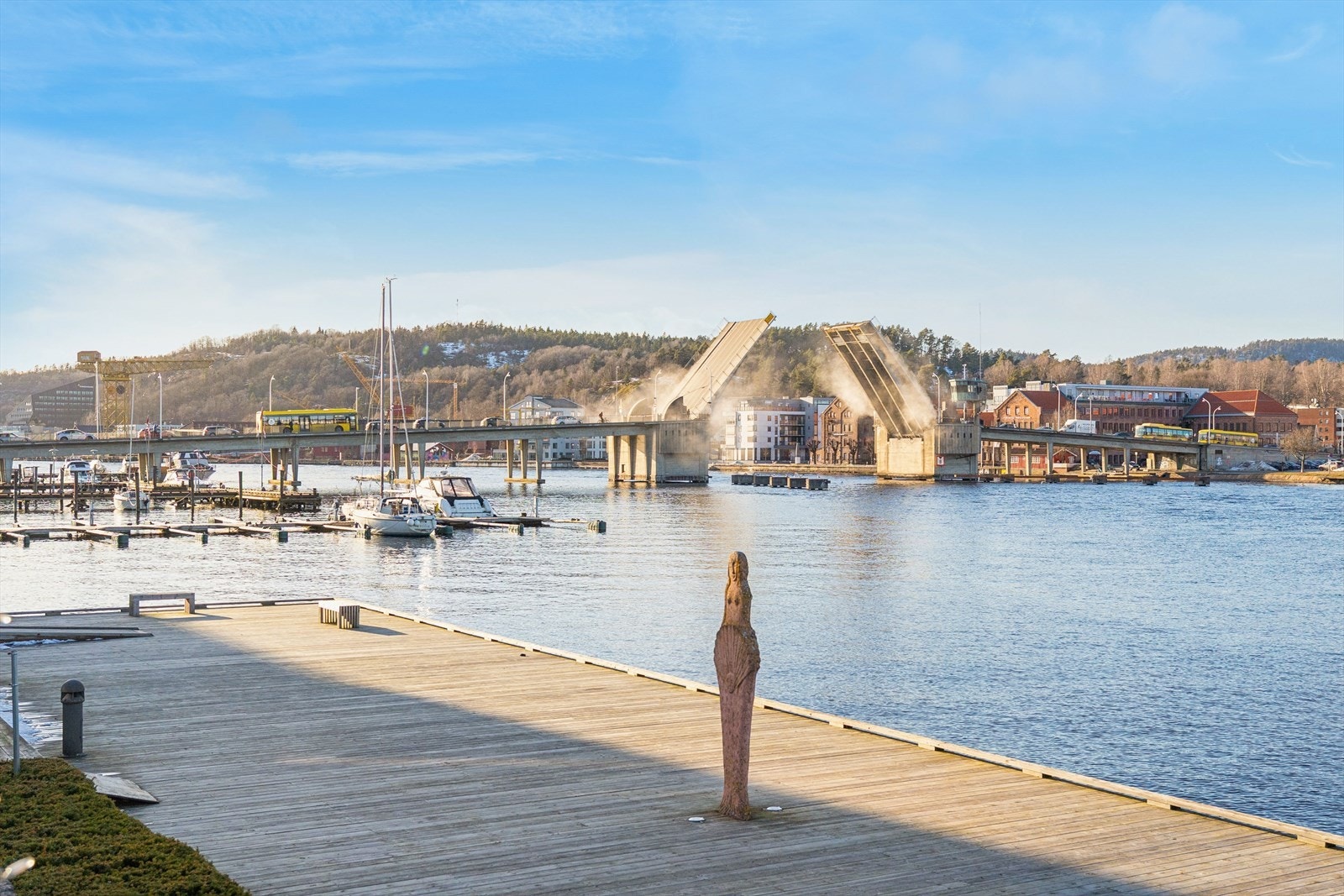 Her ser vi Porsgrunnsbrua i åpen (løftet) posisjon, sett fra området rundt Kulturhuset Ælvespeilet / Stangholmen-promenaden på østsiden av elva. Galleribilde