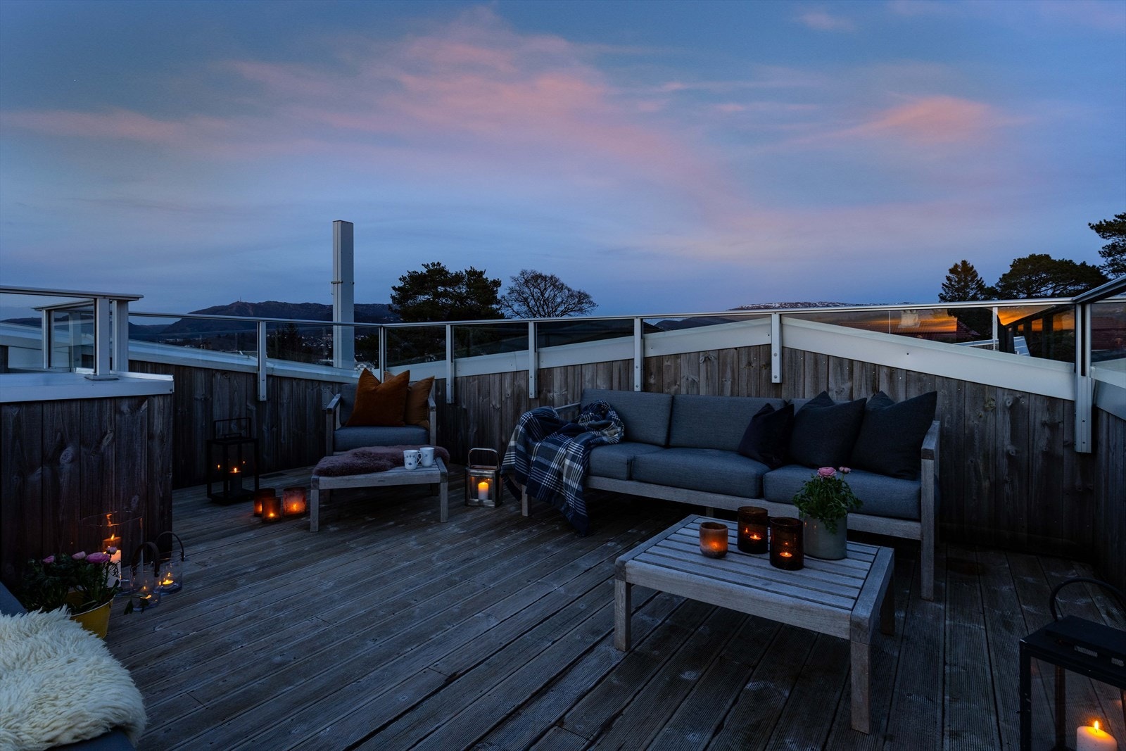 Levende lys, skinn, pledd og noe varmt i koppen! Denne takterrassen kan brukes hele året. Galleribilde