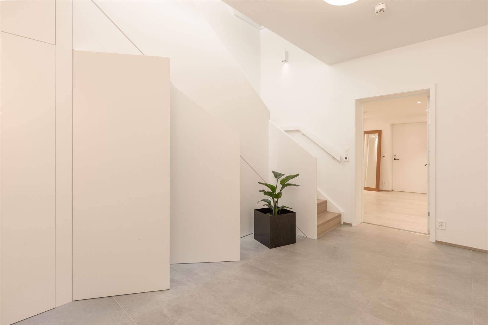 Hallen i 1. etg. med lekre fliser på gulvet og smart utnyttelse av arealet under trappen med gode skap til oppbevaring. Galleribilde