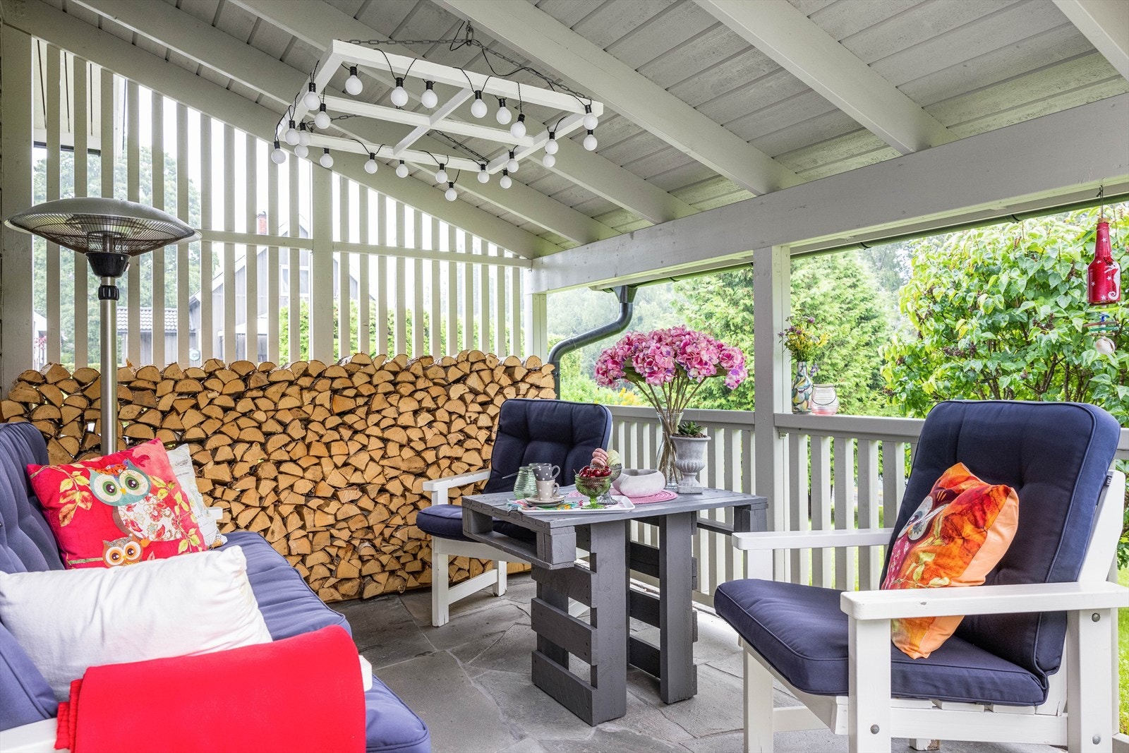 Bak garasjen er det en overbygget uteplass med god plass til utemøblement. Galleribilde