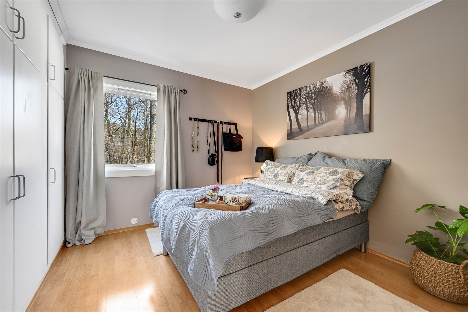 Lyst og romslig hovedsoverom med plassbygget garderobe. Galleribilde