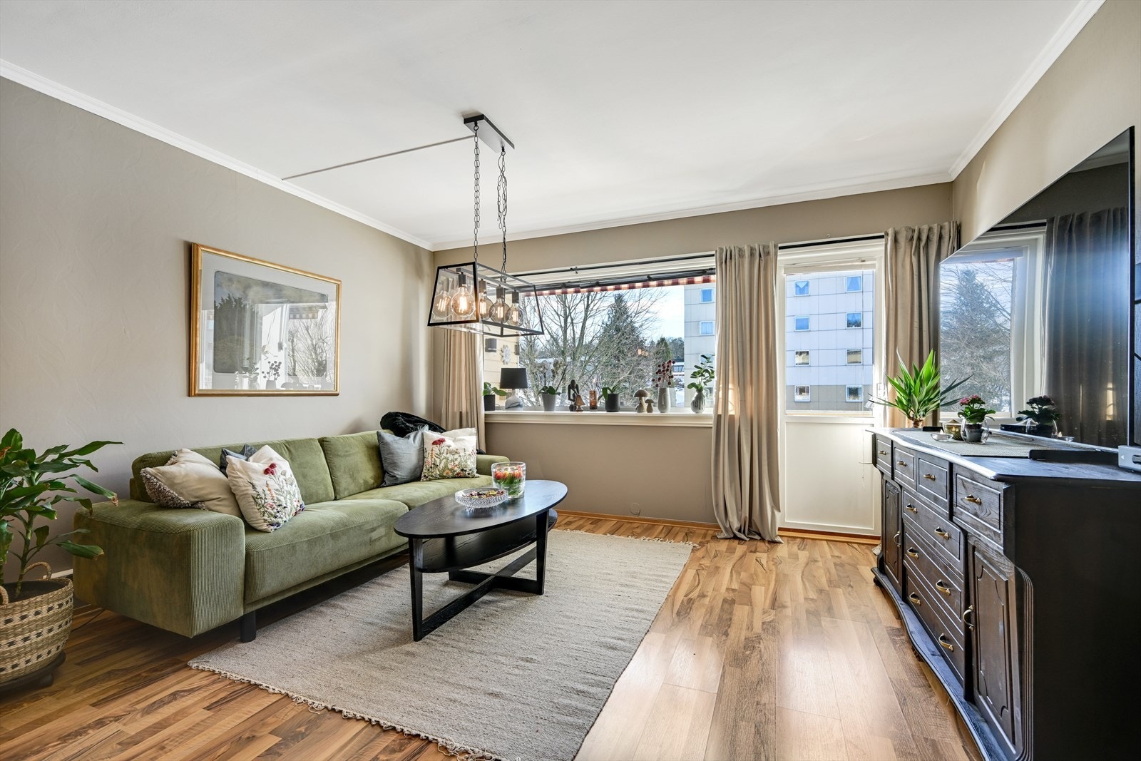 Stuen er malt i delikate og rolige farger. Utgang til balkong med ettermiddagssol. Galleribilde