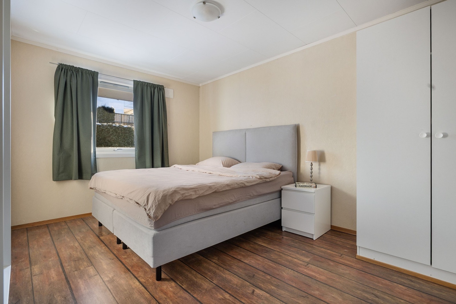 Romslig hovedsoverom med plass til dobbeltseng med nattbord og garderobeskap Galleribilde