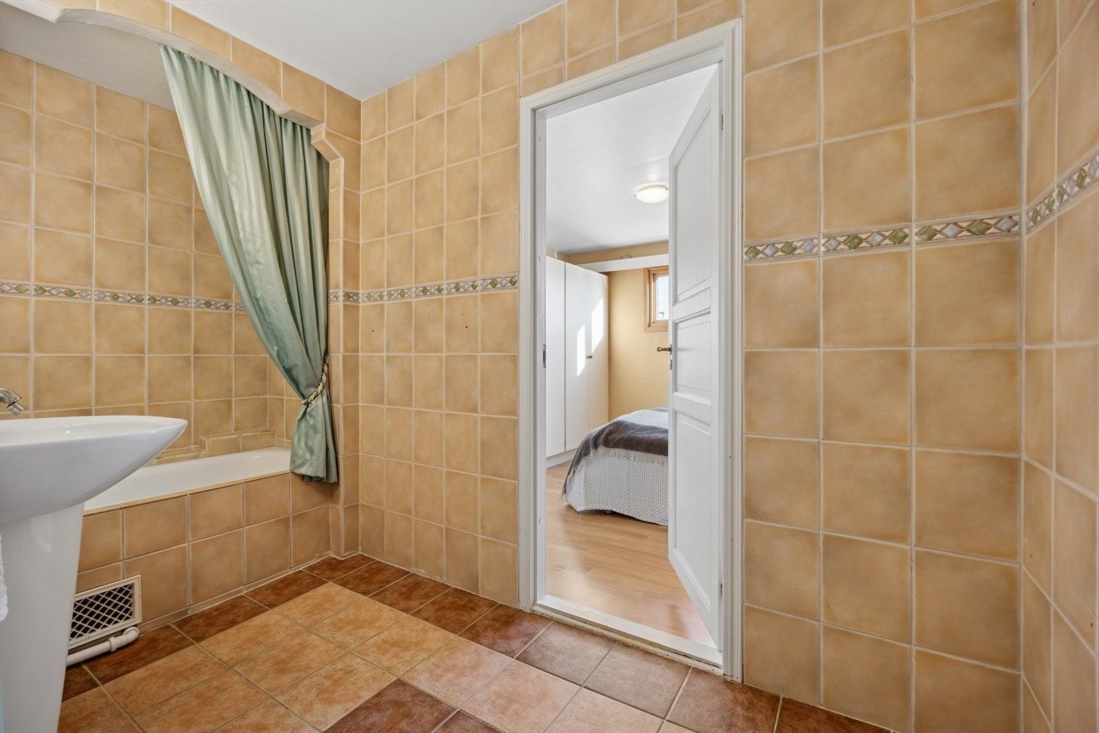 Badet byr på servant, speil, badekar med dusj-garnityr og opplegg for vaskemaskin. Galleribilde