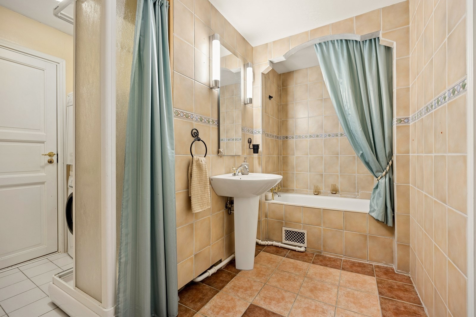 Badet er av eldre stil med flislagte gulv og vegger. Galleribilde