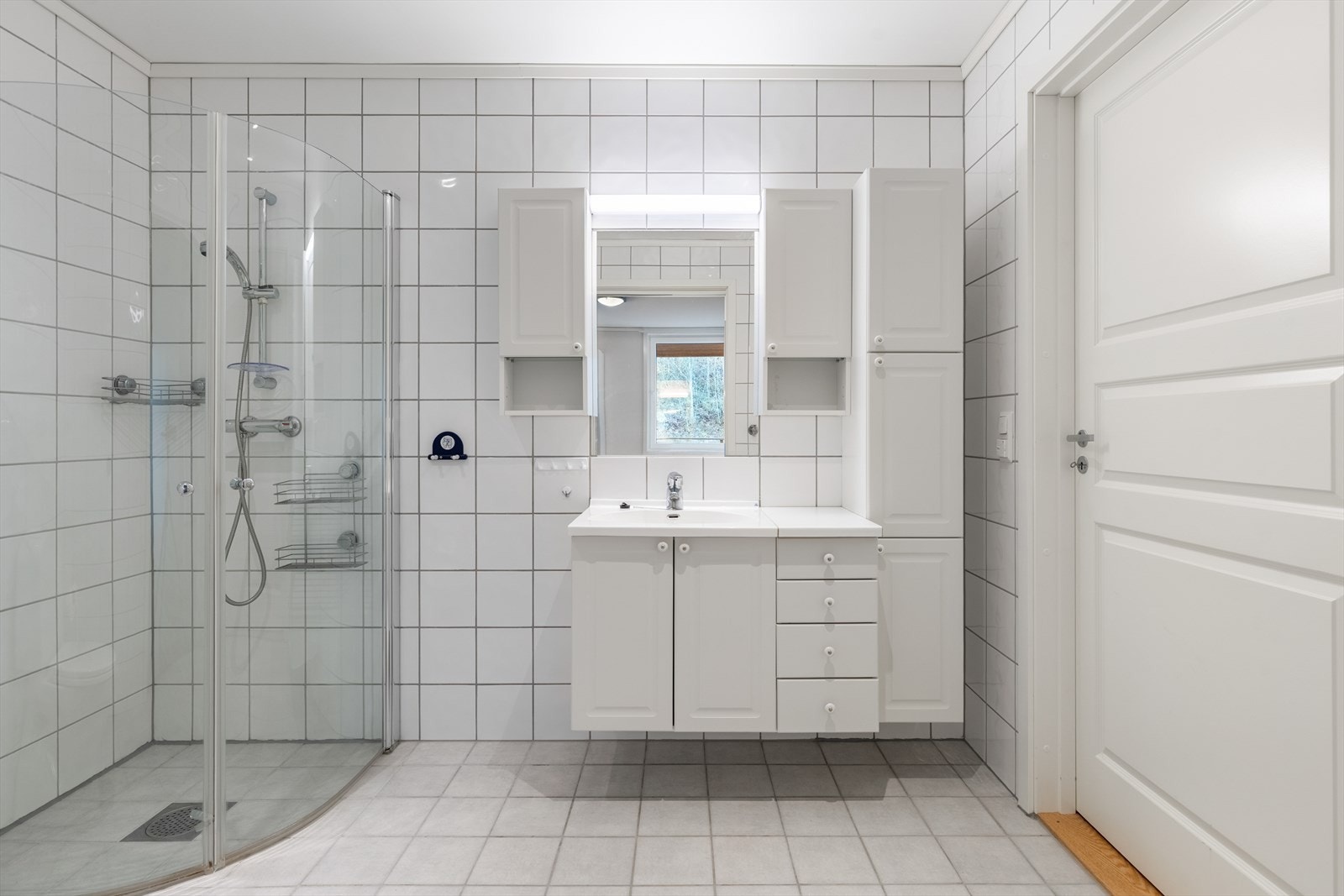 Pent flislagt bad med dusj, wc og baderomsmøbel. Godt med skap og skuffer i baderomsmøblet Galleribilde