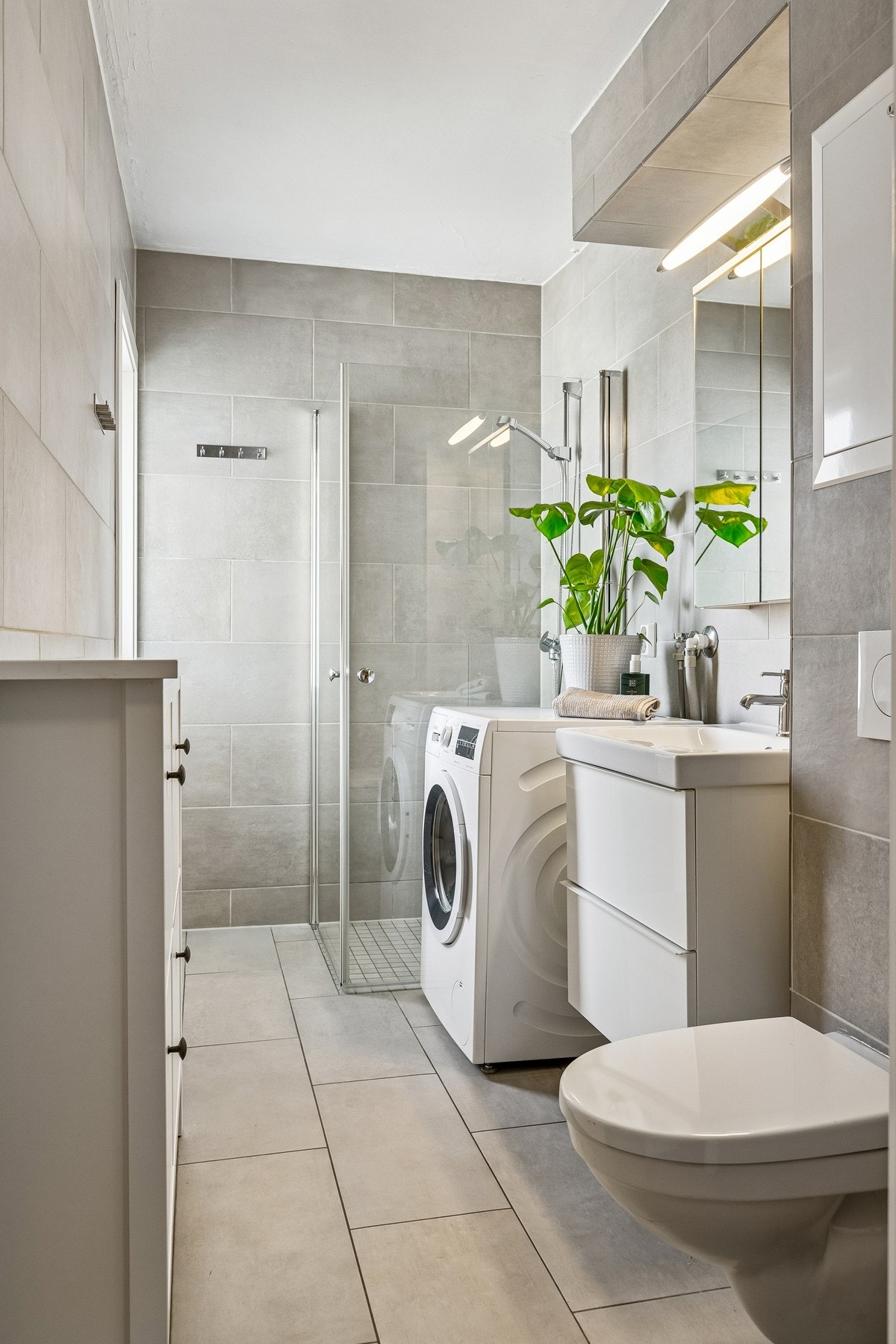 Badet fremstår som moderne. Her får du dusj med innfellbare dører, opplegg til vaskemaskin og vegghengt toalett. Moderne innredning med heldekkende servant. Galleribilde