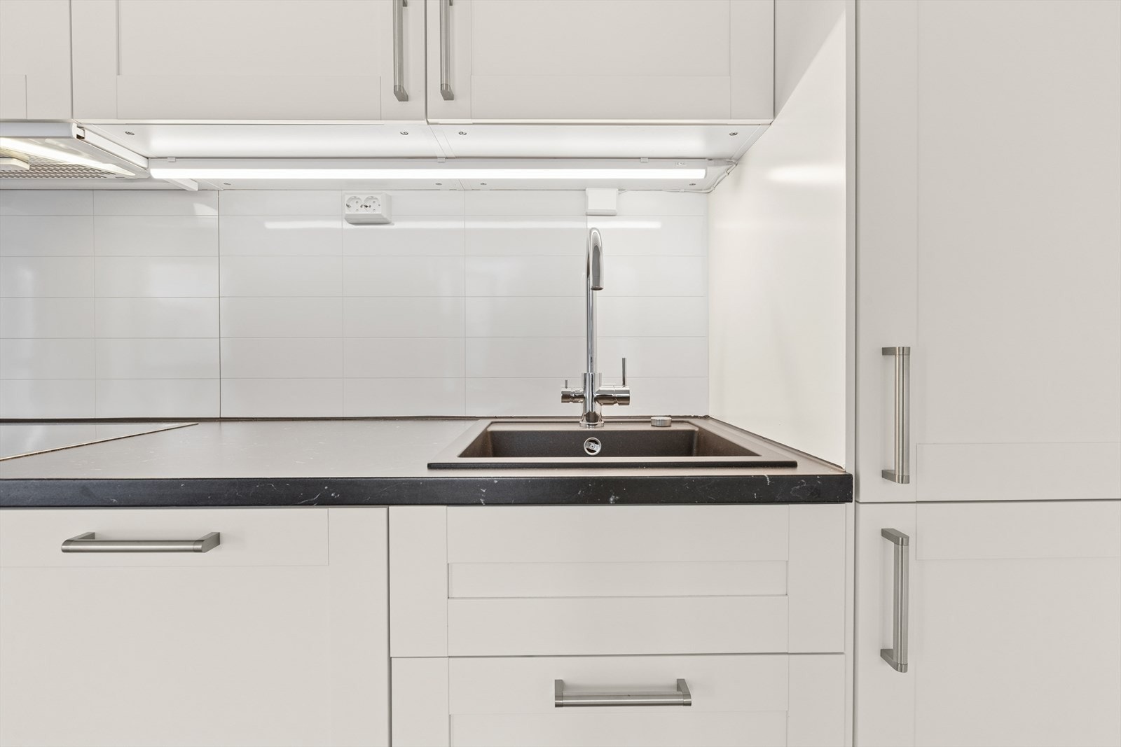 Benkeplaten av laminat og nedfelt vask gir en funksjonell arbeidsflate. Galleribilde