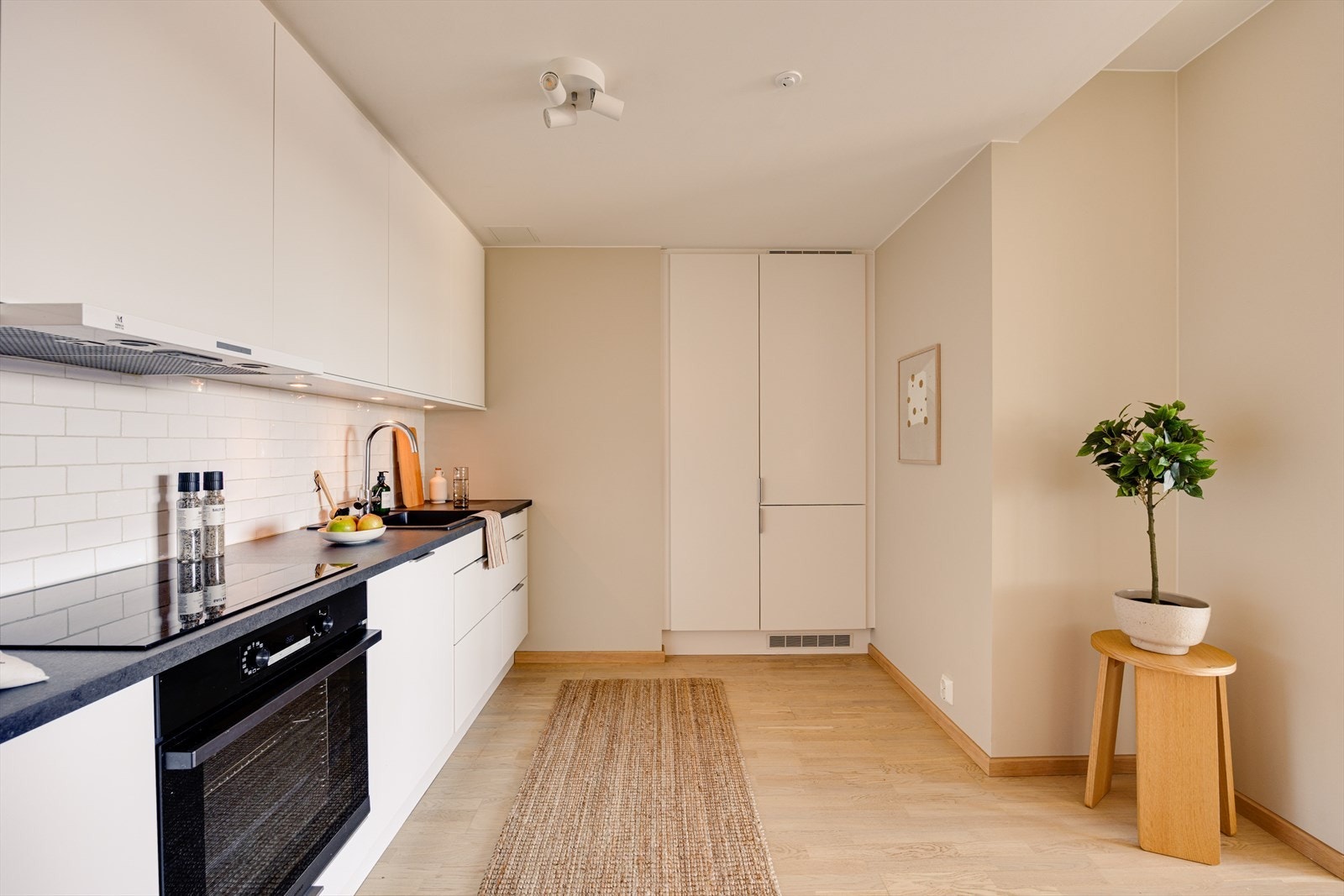 Klassisk og pent kjøkken med slette fronter og integrerte hvitevarer. Galleribilde