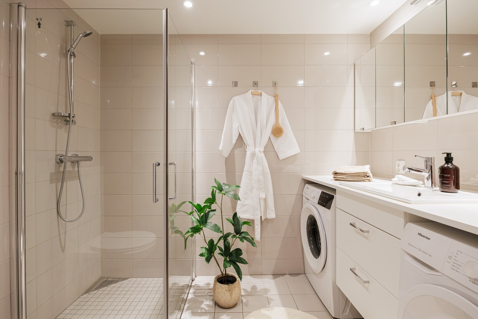 Lekkert baderom med moderne farger på fliser, gulvvarme og downlights. Galleribilde