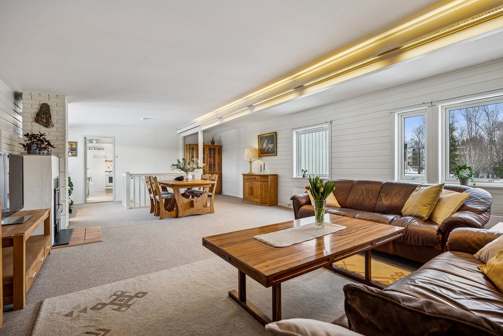 Den romslige stuen er utvidet og fremstår luftig med god plass til både sofagruppe og sosiale sammenkomster. Galleribilde