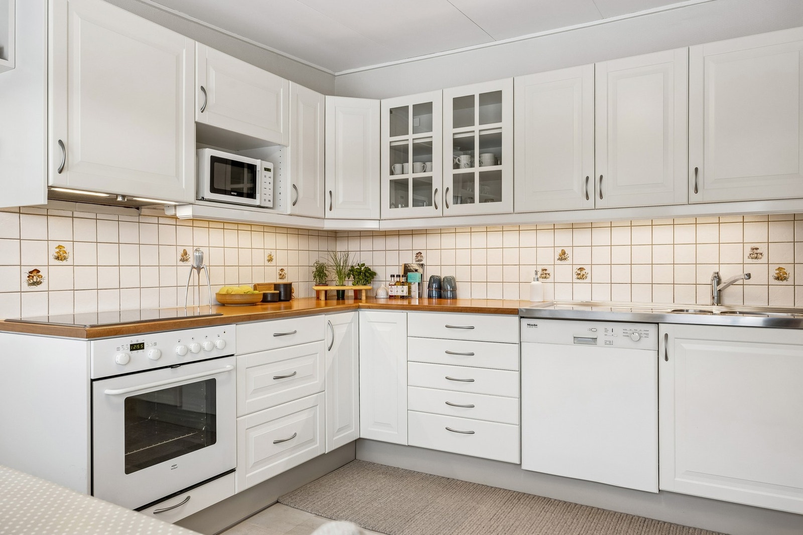 Lys kjøkkeninnredning med laminert benkeplate og nedfelt oppvaskkum. Galleribilde