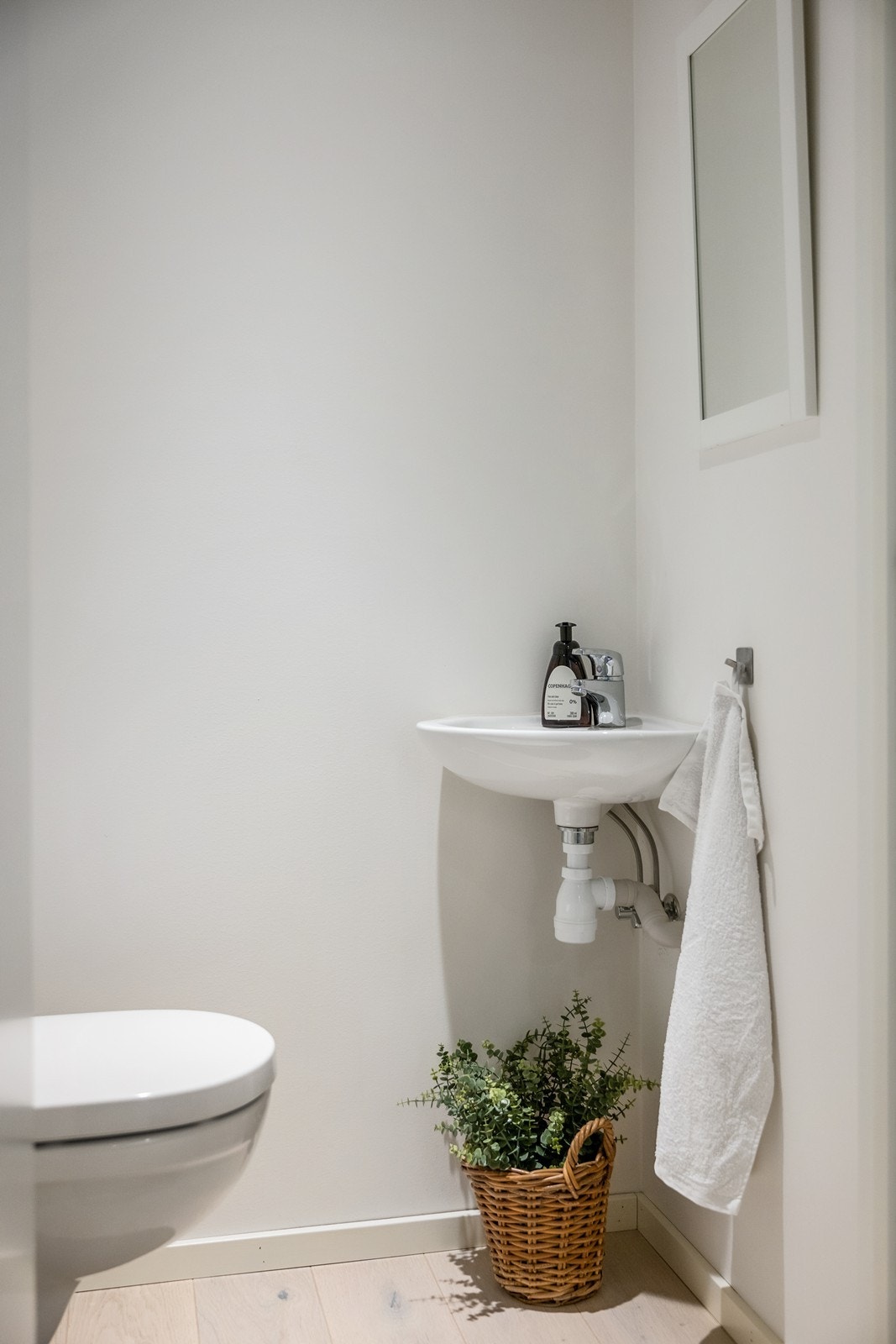 I 1. etasje er det et praktisk separat gjestetoalett med malte vegger og parkett på gulv. Her er det vegghengt toalett og vegghengt vask. Galleribilde