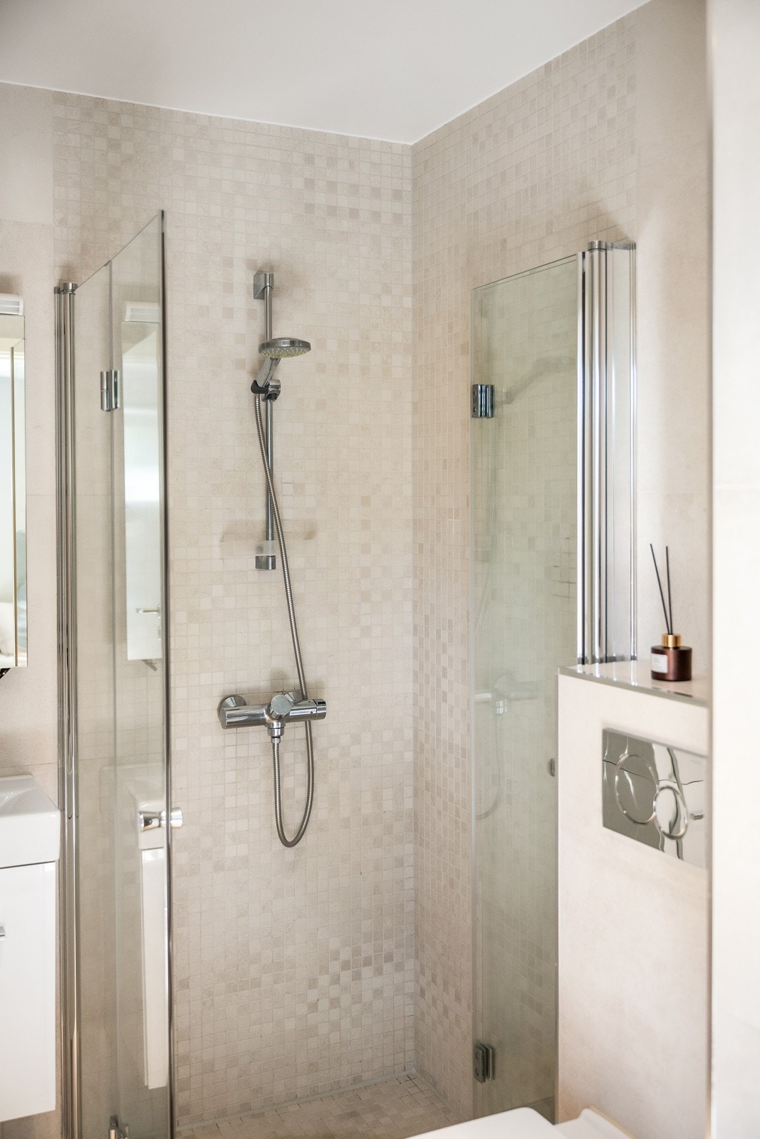 Badet er helfliset med elektriske varmekabler i gulvet. Her er det installert vegghengt innredning med heldekkende servant og ettgreps blandebatteri, vegghengt toalett og innfellbare dusjdører av glass. Galleribilde