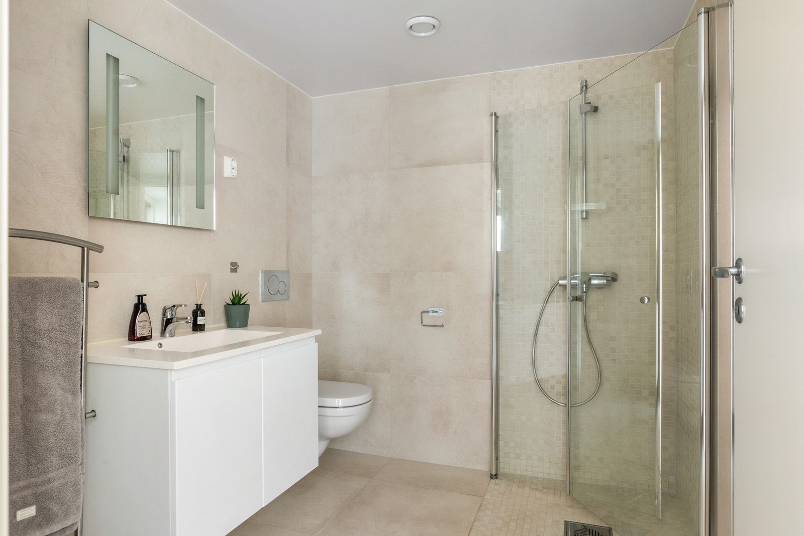 Badet i tilknytning til hybelen er flislagt med elektriske varmekabler.Her er det installert vegghengt innredning med heldekkende servant og ettgreps blandebatteri, vegghengt toalett og innfellbare dusjdører av glass og opplegg for vaskemaskin. Galleribilde