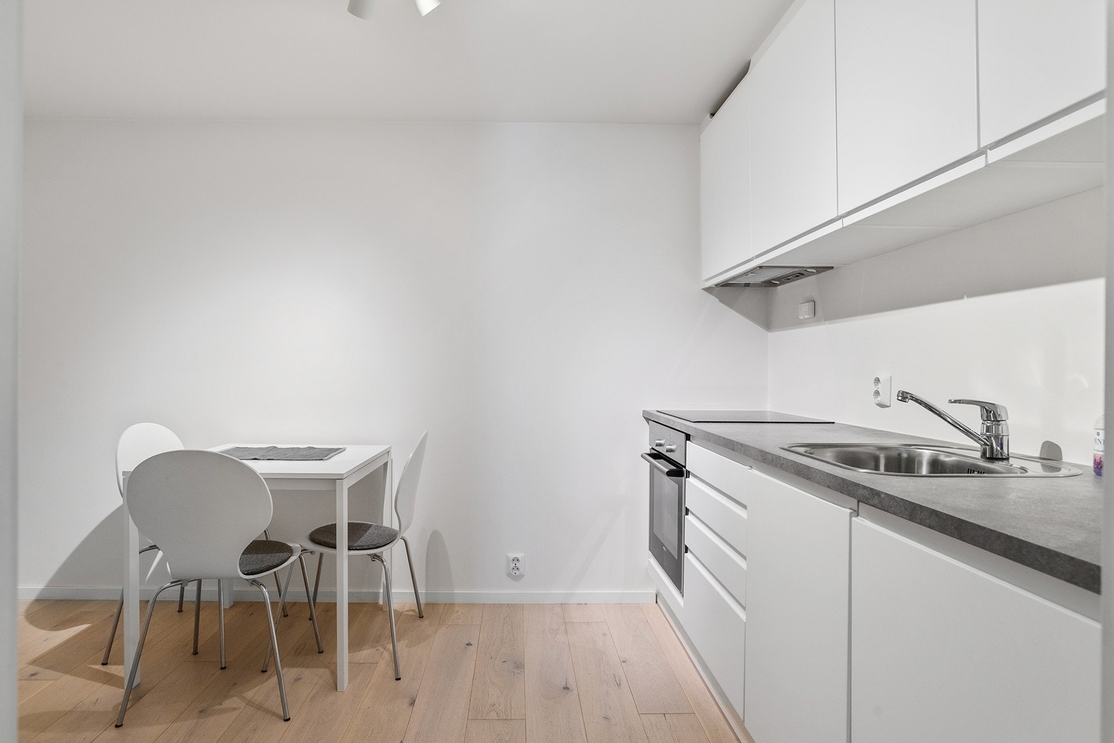 Hybelkjøkken fra JKE design med matte slette skapfronter og laminert benkeplate (det gjøres oppmerksom om at kjøkkenet er etablert i et rom som er godkjent som bod). Galleribilde