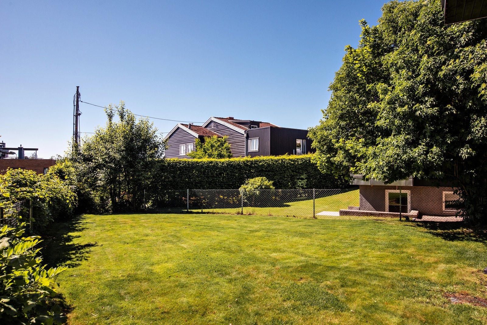 Her er det en stor flat gressplen i front av huset, perfekt for den aktive familien eller sommerfesten. Galleribilde