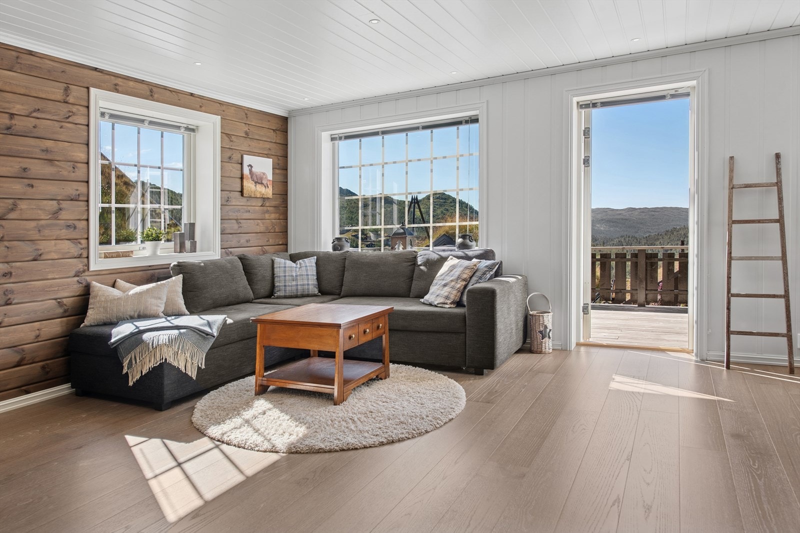 Stuen er lys og luftig med vinduer mot flere himmelretninger, godt med naturlig lys og familievennlig møblering. Her er det god plass til både familie og venner, perfekt for hyggelige stunder på hytta. Galleribilde