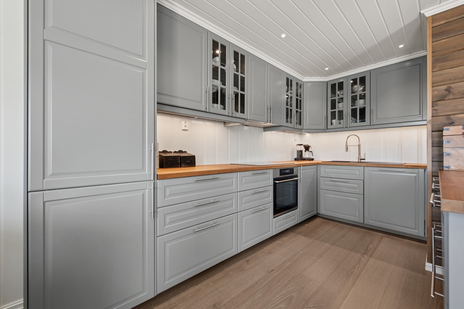 Kjøkkenet er innredet med over- og underskap med profilerte fronter og benkeplate i eik. Her er det godt med både benk- og skapplass - perfekt for hyggelige måltider og matlaging på hytta Galleribilde