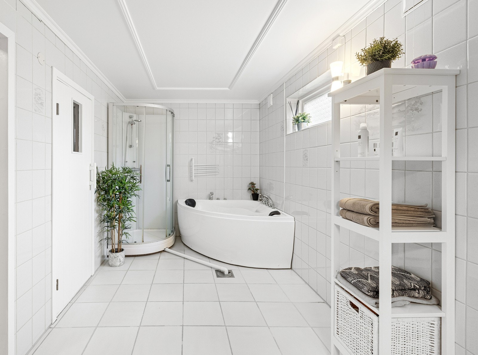 Her finner du både dusjkabinett og innbydende badekar. Rommet har god plass til oppbevaring, samt vindu som slipper inn naturlig lys. Galleribilde