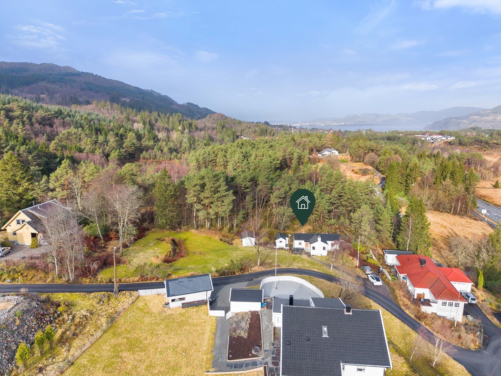 Tomten er opparbeidet med blant annet asfalterte vei, grus, biloppstillingsplass, plenarealer og andre forskjellige beplantninger Galleribilde