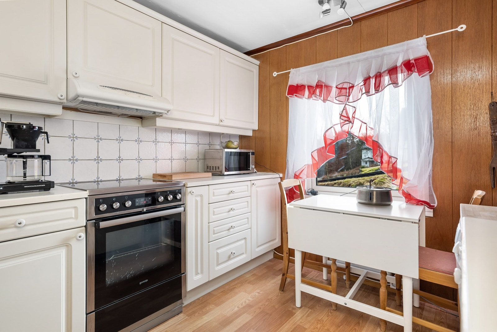 Det er lagt fliser mellom kjøkkenbenk og overskap Galleribilde