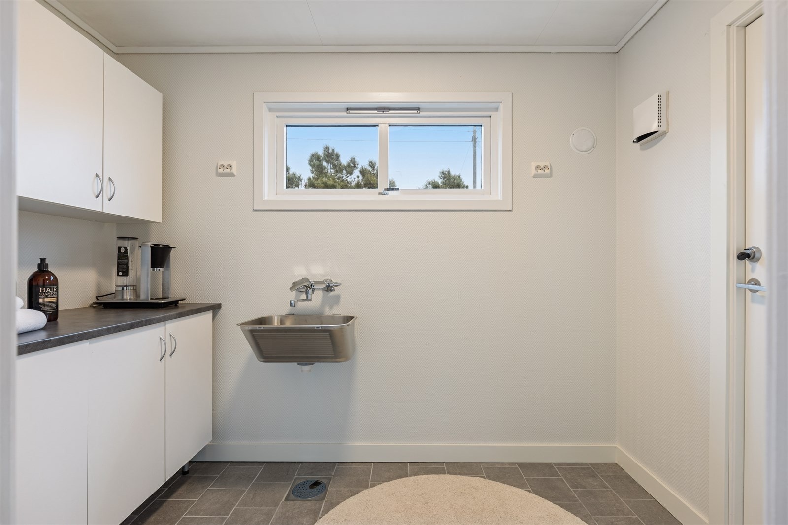 Praktisk vaskerom med tilknytning til kjøkkenet og direkte utgangsdør til hagen. Galleribilde