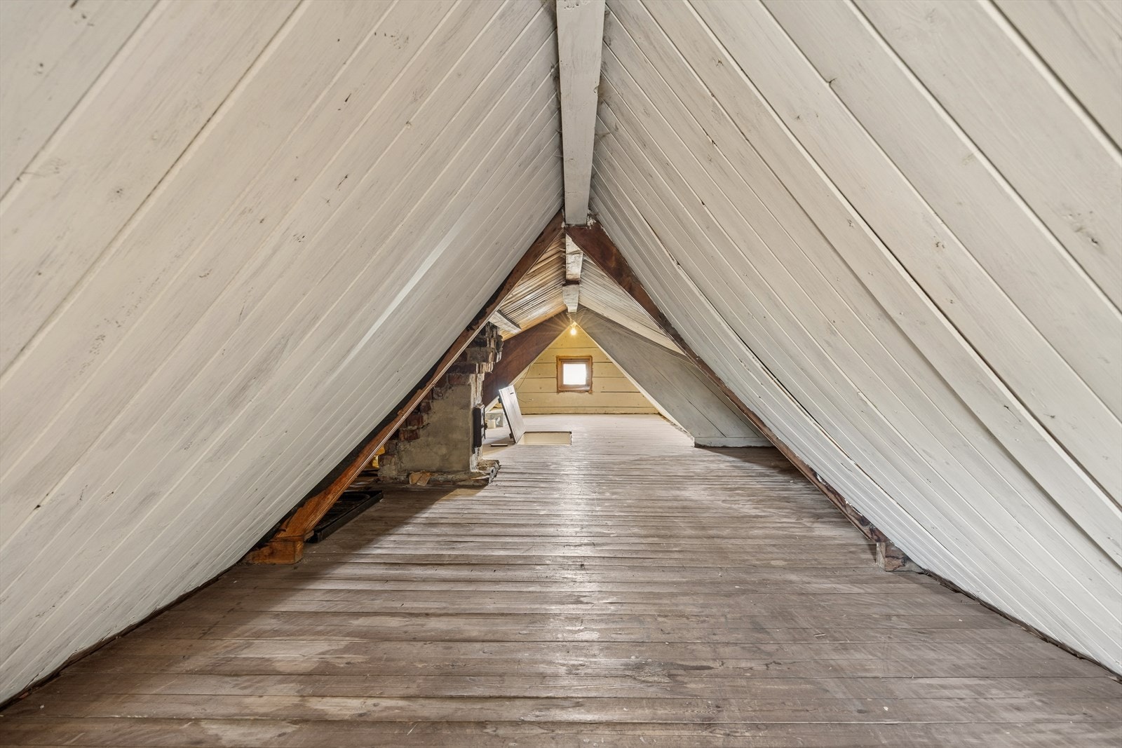 Loftet har synlig takkonstruksjon og en mursteinspipe med feieluke. Galleribilde