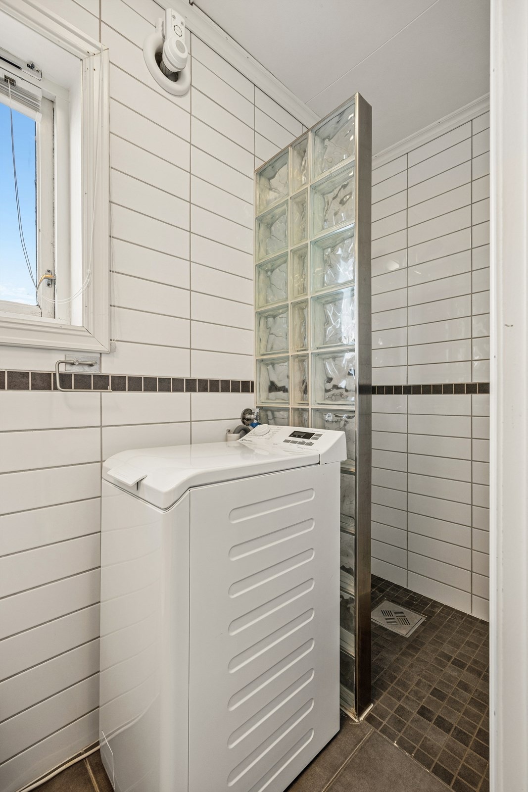 Badet er flislagt og har opplegg for vaskemaskin, som medfølger. Galleribilde