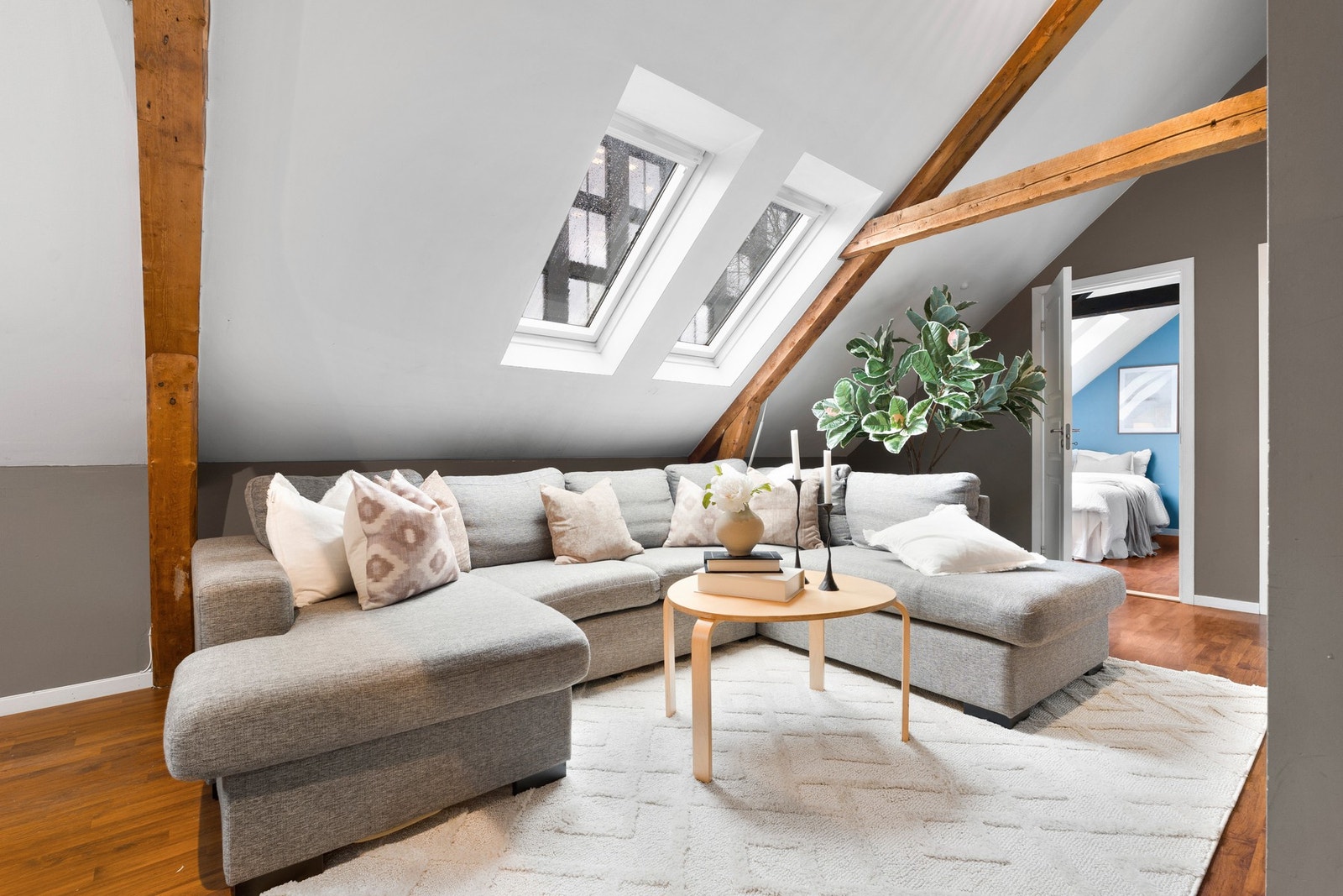 Lyst og trivelig oppholdsrom med god plass til en romslig sofagruppe. Skråtak, synlige bjelker og takvinduer gir stuen en unik og stemningsfull karakter. Galleribilde