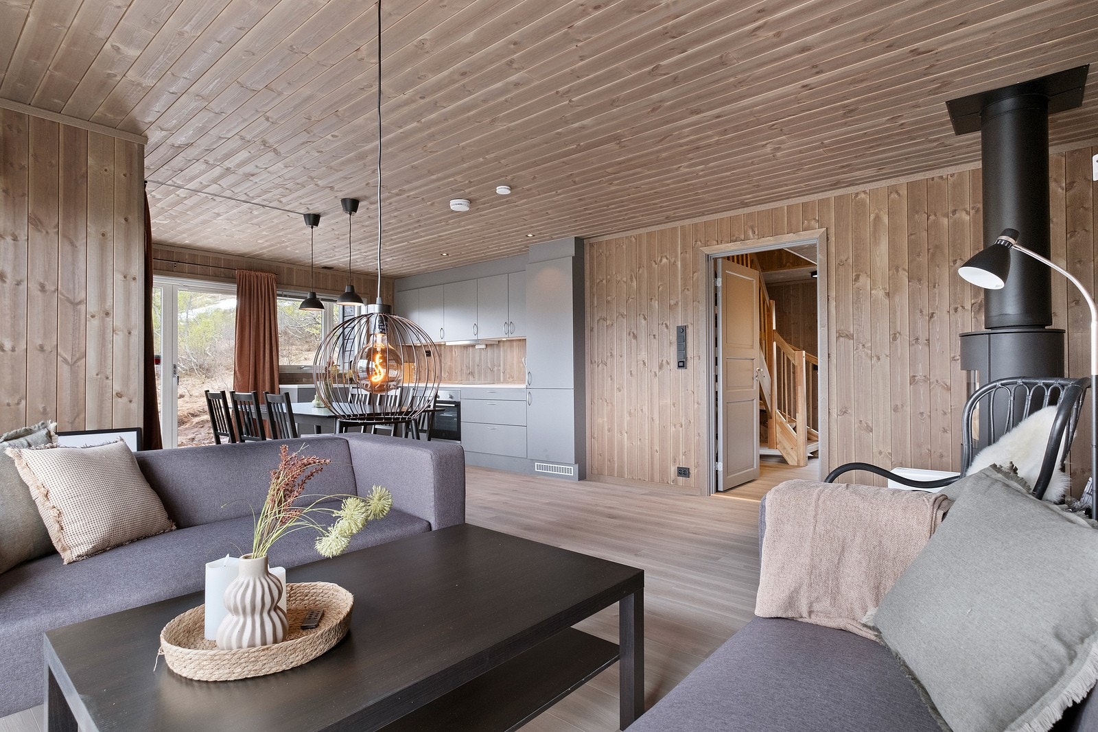 Stuen har store vindusflater og flott utsikt. På gulvet finner vi en lys og moderne laminat, og vegger og tak i drivved-farge. Galleribilde