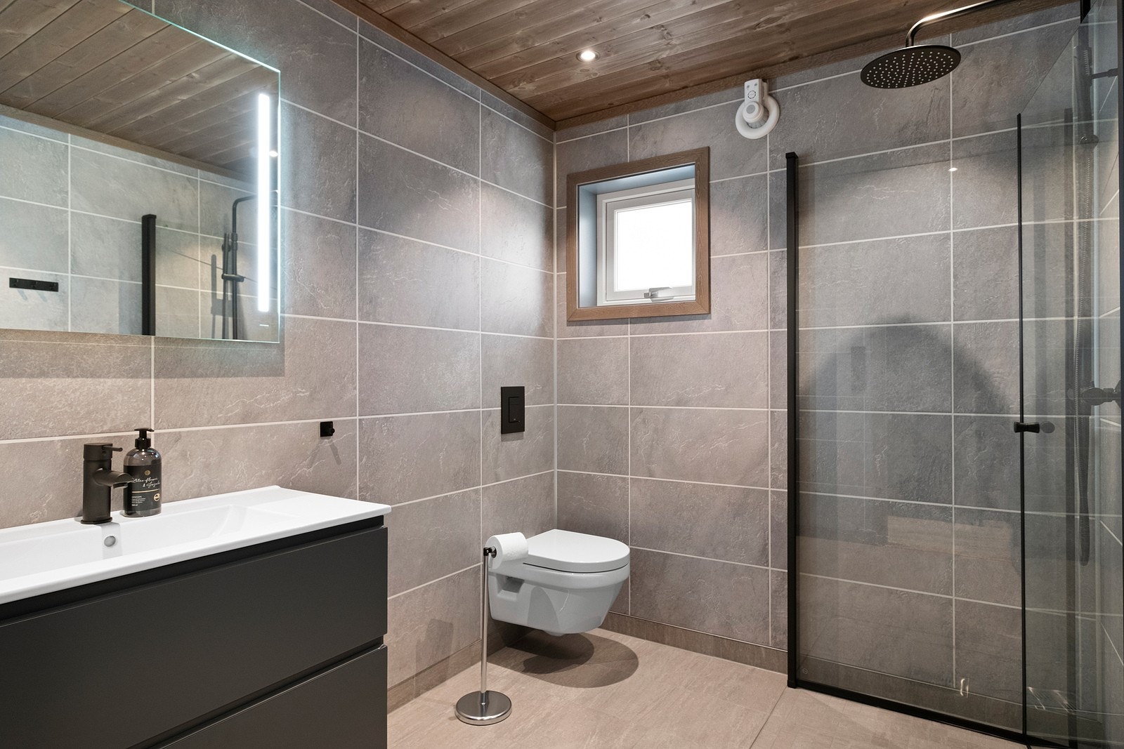 Meget pent og moderne bad med tidsriktige fargevalg og løsninger med bla. svarte detaljer og waterfall-dusj. Galleribilde