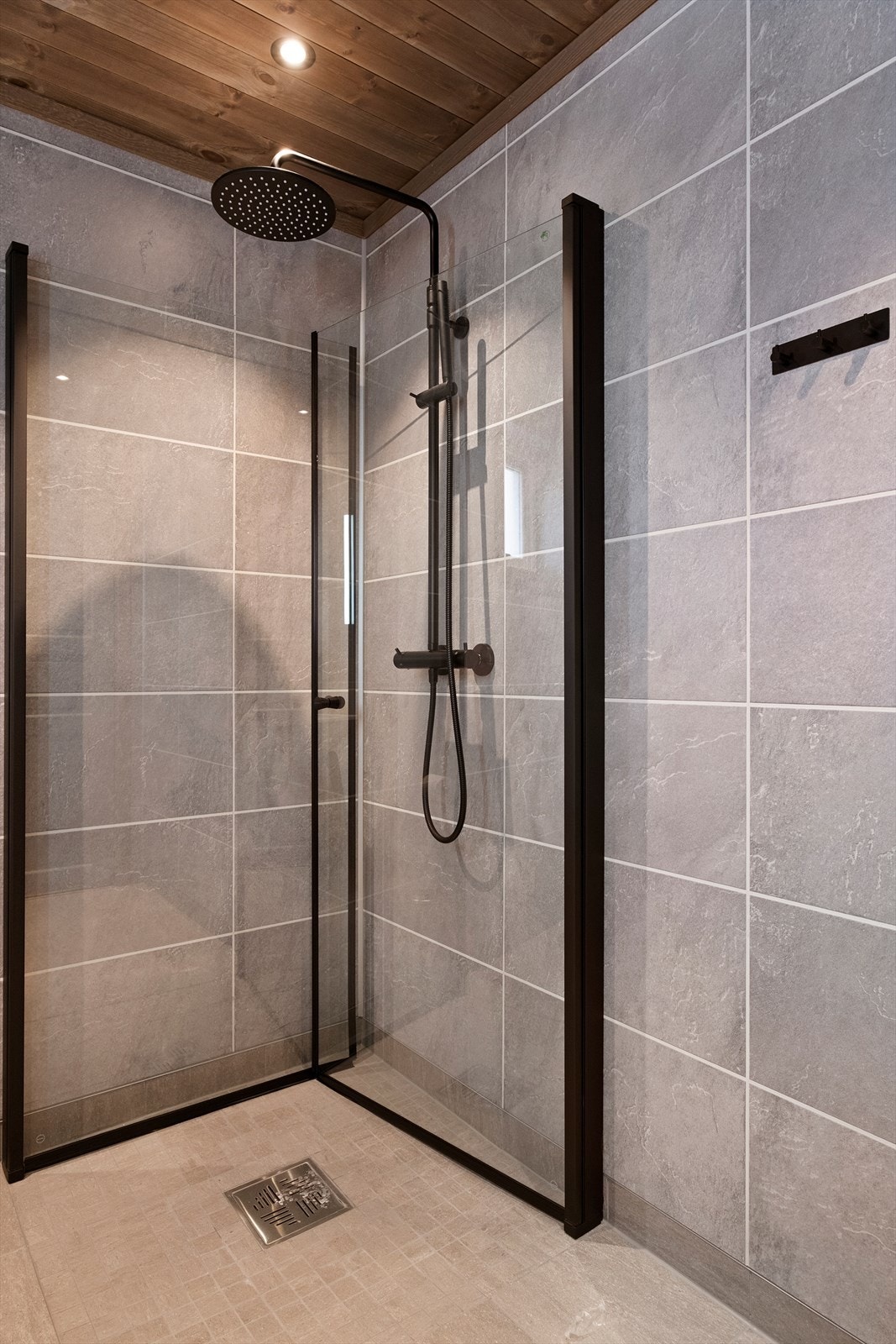 Meget pent og moderne bad med tidsriktige fargevalg og løsninger med bla. svarte detaljer og waterfall-dusj. Galleribilde