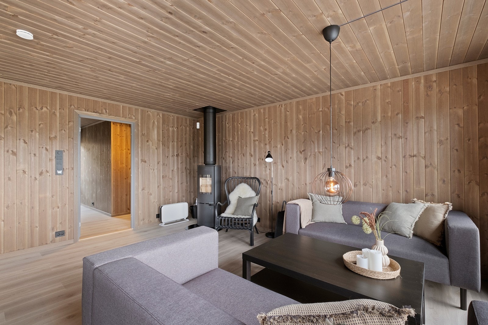 Stuen har store vindusflater og flott utsikt. På gulvet finner vi en lys og moderne laminat, og vegger og tak i drivved-farge. Galleribilde