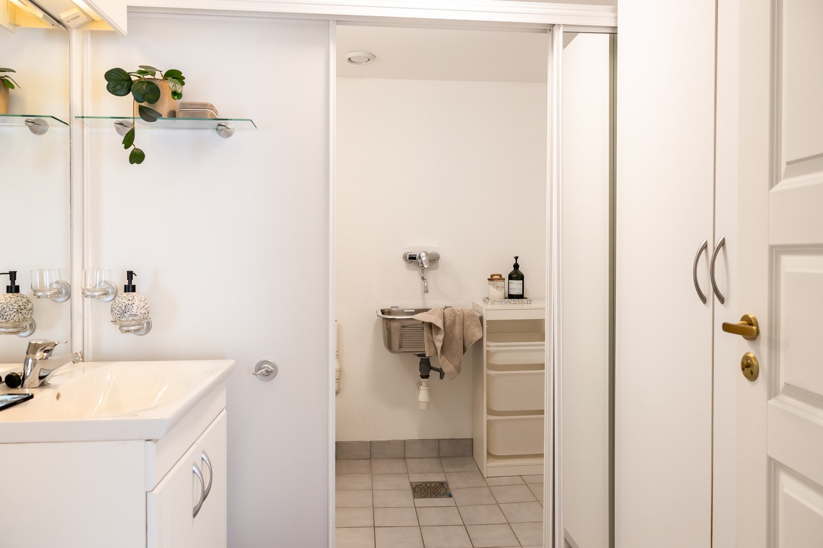 Toalett-sone har toalett og baderomsinnredning. Vaskerom-sone har utslagsvask og opplegg for vaskemaskin og tørketrommel. Rommet har fliser på gulv og strie på vegger. Galleribilde