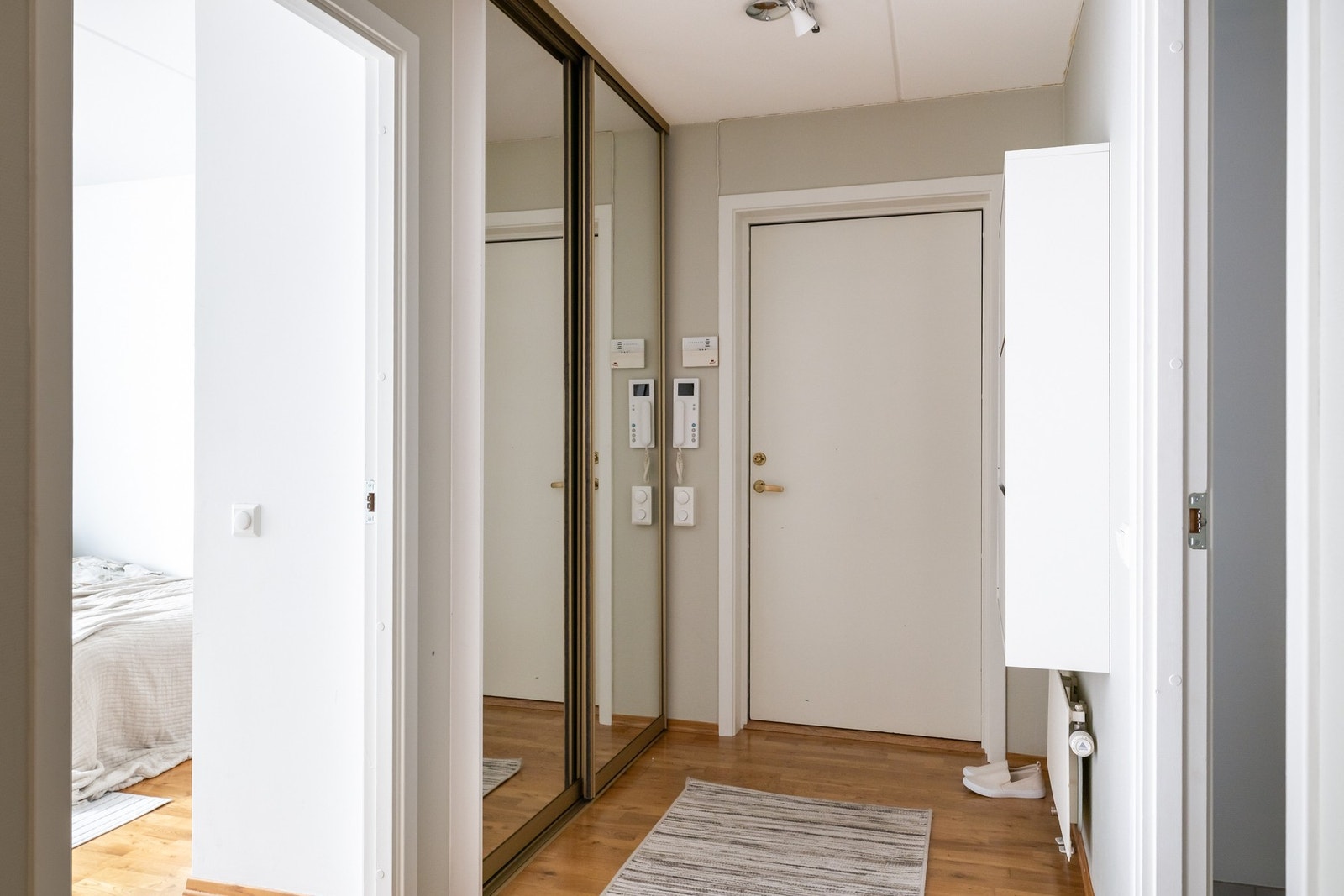 Man kommer inn i en romslig gang på 15,5m². Gangen er utstyrt med skyvedørsgarderobe og skoskap. Porttelefon med kamera. Galleribilde