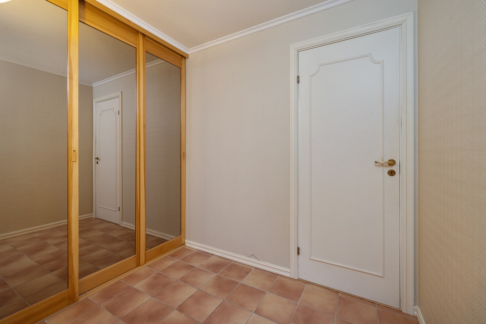 I gangen er det en romslig skyvedørsgarderobe med speilfronter Galleribilde