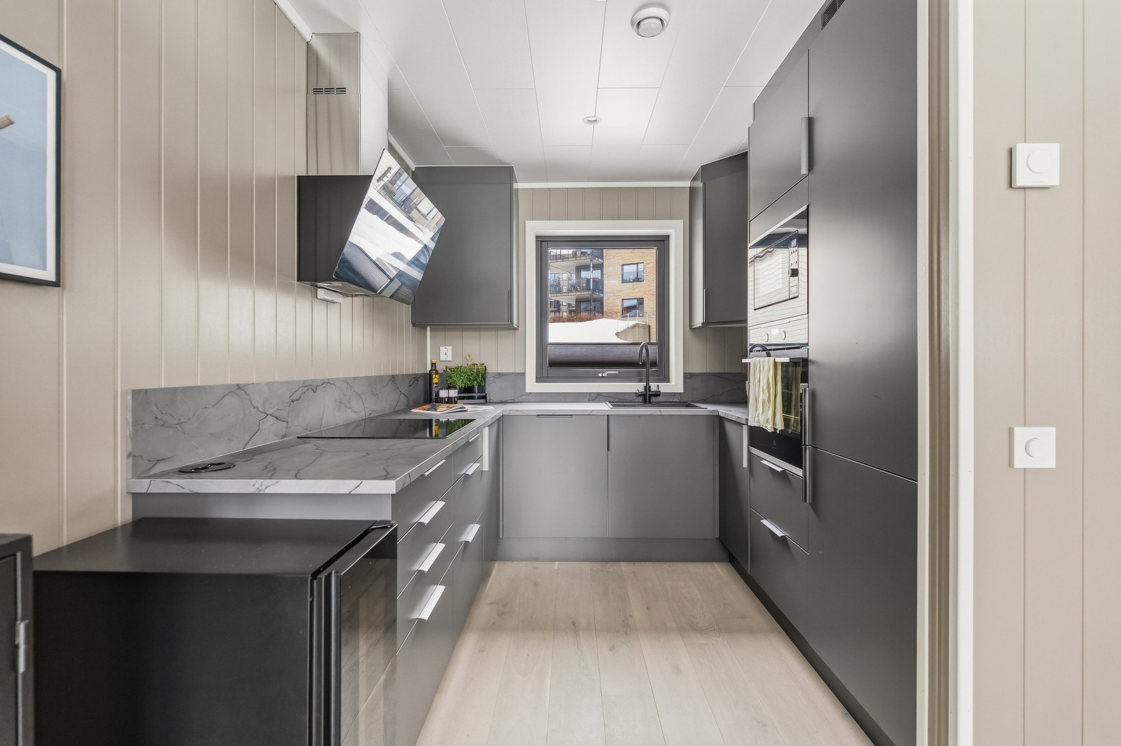 Kjøkkenet har moderne med glatte fronter og laminat benkeplate med nedfelt oppvaskkum og ettgreps blandebatteri. Galleribilde