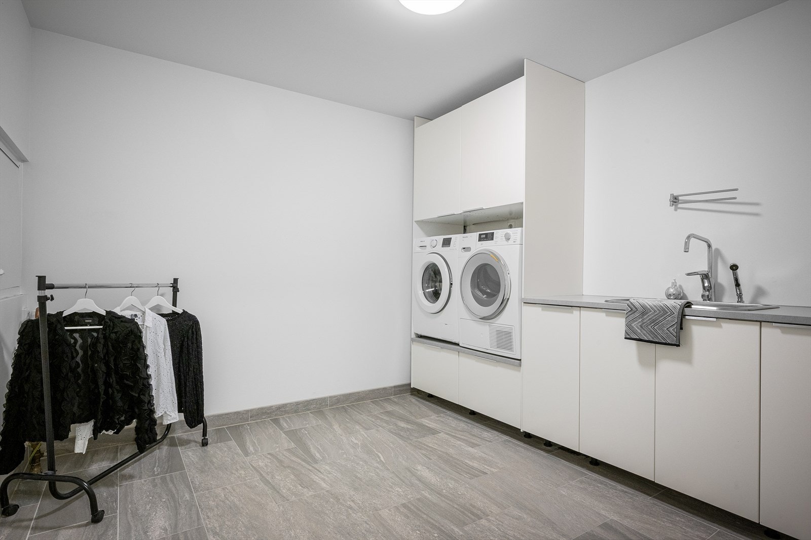 Stort og godt vaskerom m/god plass til tørking av klær. Mye skapplass og smart innredning m/arbeidsbenk. Galleribilde